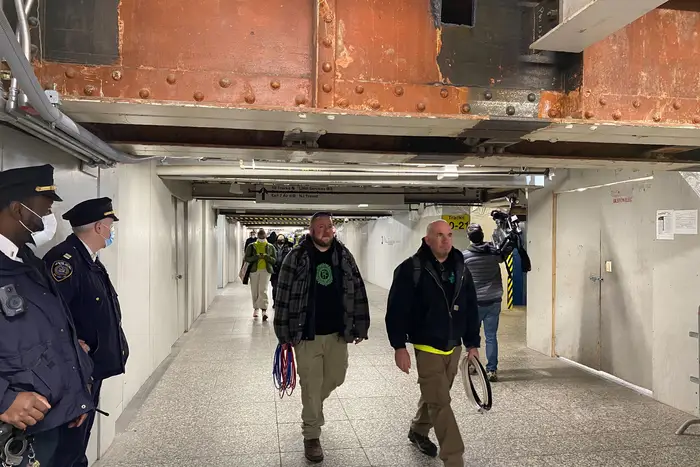 Photographs showing people inside the Long Island Rail Road concourse at Penn Station, which is partly under construction, and partly dingy